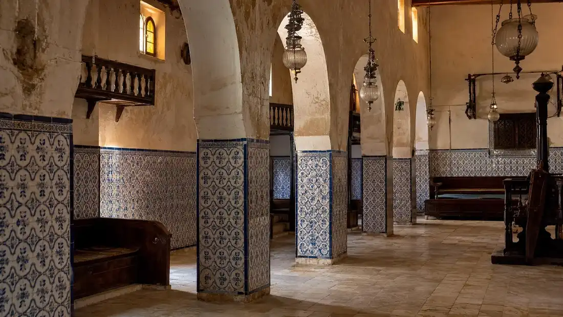 Interiér synagogy El Ghriba s oblouky a modrobílými tuniskými kachlíky